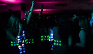 Energetic nightclub scene with people dancing under colorful neon lights. Perfect for nightlife themes.
