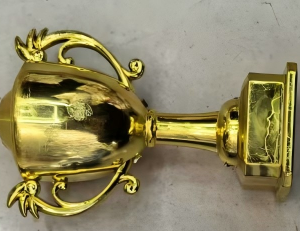 Two mixed cake ornaments, gold trophy